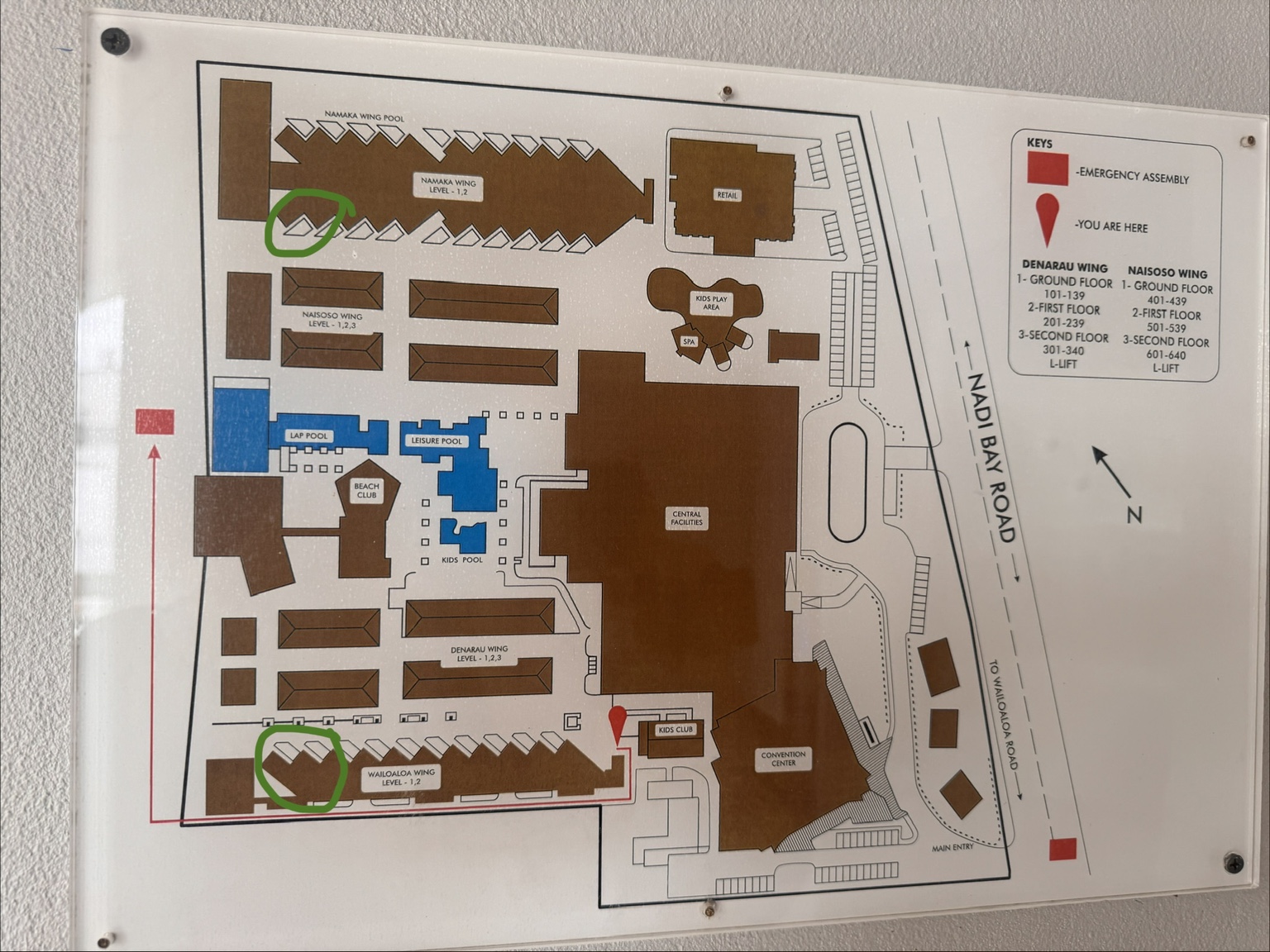 Photograph of the Crowne Plaza Nadi site map, with green circles around end-of-block room positions in the Namaka and Wailoaloa wings