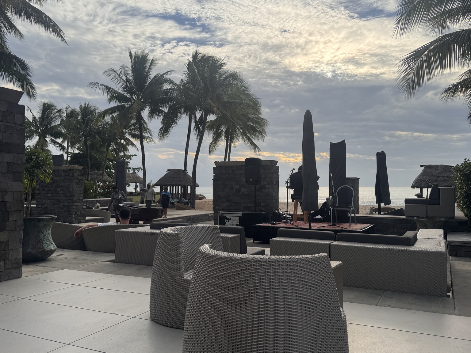 Beachside lounge seating and a live musician with the ocean beyond