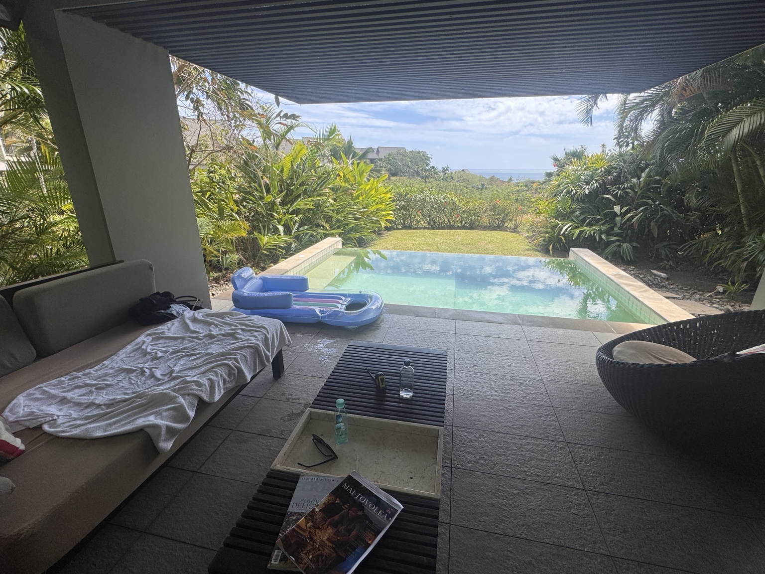 Covered terrace with sofa and a private plunge pool looking towards the sea