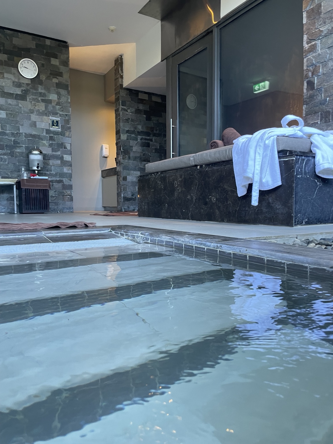 Spa pool with cushioned seating, robes and a refreshment station